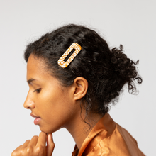 Load image into Gallery viewer, A woman stands in profile, wearing a tortoise hair clip in cream and light brown, with her hair loosely pulled up into a knot at the nape of her neck.
