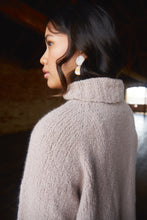 Load image into Gallery viewer, An Asian American woman wears a pale pink fuzzy raglan sweater with a turtleneck collar, and large white earrrings.
