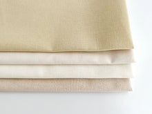 Load image into Gallery viewer, A stack of four fat quarters of cotton and linen-cotton fabrics in neutral colors.
