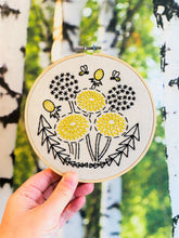 Load image into Gallery viewer, A small embroidered design in yellow and black thread of stylized dandelions and bumblebees.
