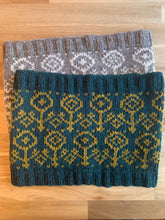 Load image into Gallery viewer, Two knit cowls, one in gray and white and one in dark aqua and yellow, with ribbed edges and a colorwork flower motif.
