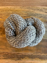 Load image into Gallery viewer, A skein of white and light gray marled yarn.
